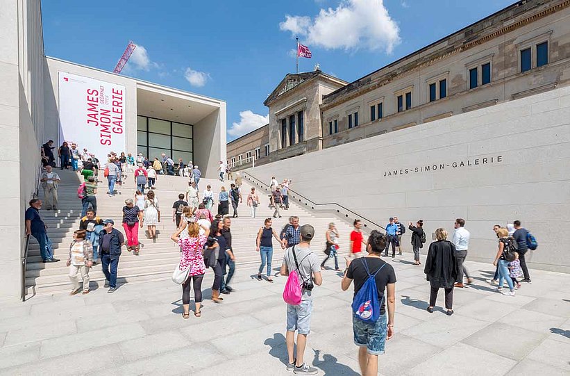 Viele sommerlich gekleidete Besucherinnen und Besucher auf dem großen Treppenaufgang der James-Simon-Galerie (öffnet Vergrößerung des Bildes)