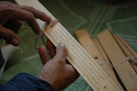 Ein Mann liest ein Manuskript auf Palmblättern
