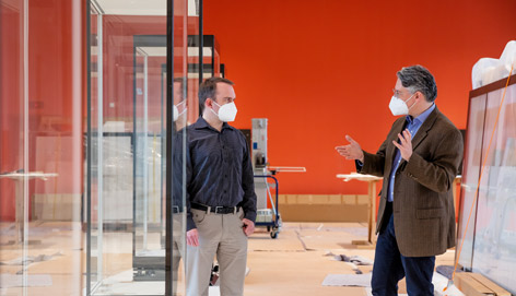 Zwei Männer unterhalten sich in einem leeren Ausstellungsraum