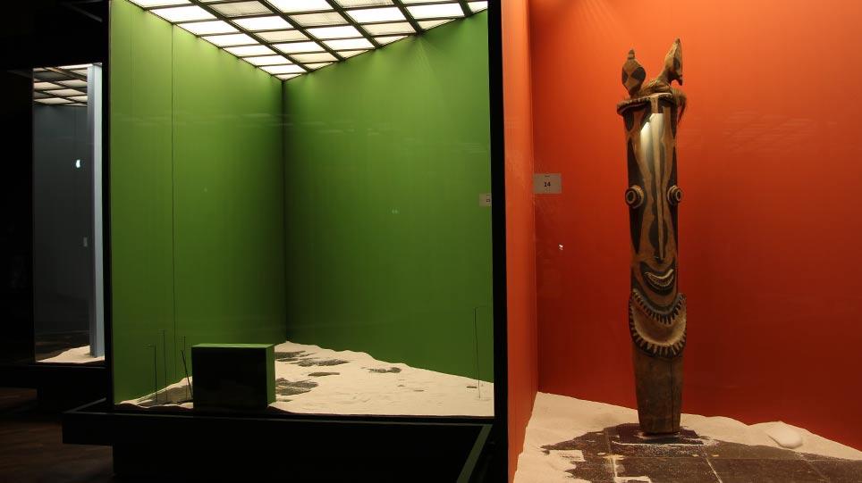 Zu sehen ist neben bereits leeren Vitrinen eine noch ausgestellte farbige Pfahlskulptur aus Südwest-Neubritannien (öffnet Vergrößerung des Bildes)