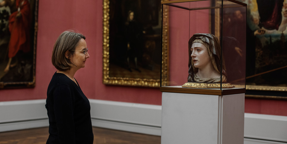 Eine Frau sieht sich ein Ausstellungsstück im Museum an.