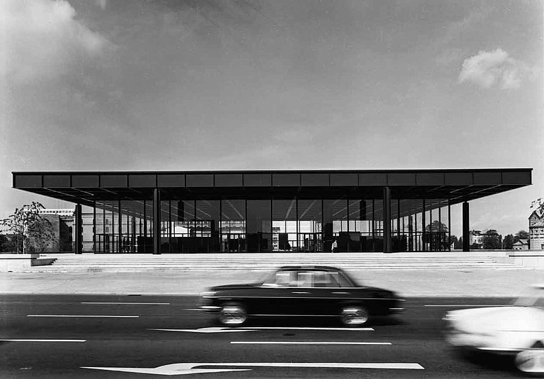 Schwarz-Weiß Fotografie mit Blick auf ein modernes Gebäude hinter einer befahrenen Straße (öffnet Vergrößerung des Bildes)