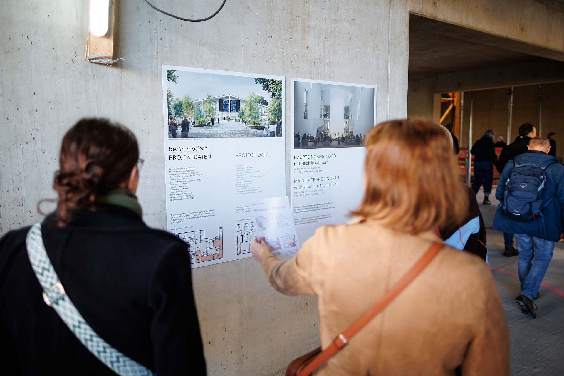 Personen vor Infotafeln auf Baustelle