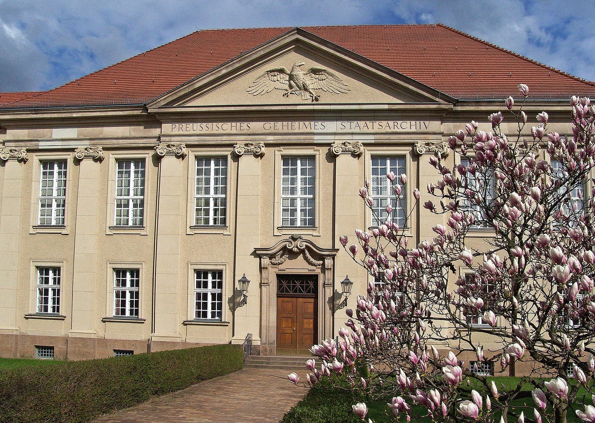 Blick auf ein Gebäude, davor Kirschblüte