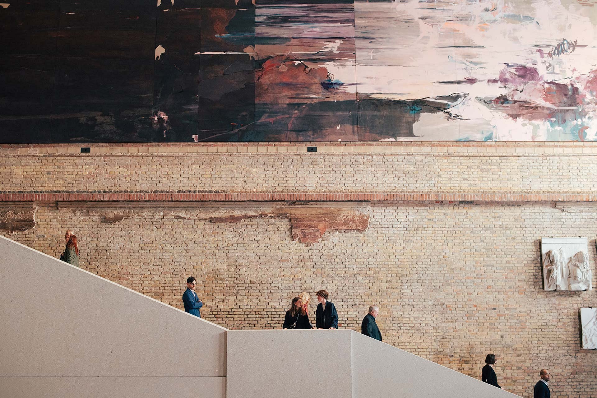 Menschen auf einer Treppe unter Kunstwerk