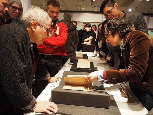 4A_Lab Menschen beugen sich über historische Bücher