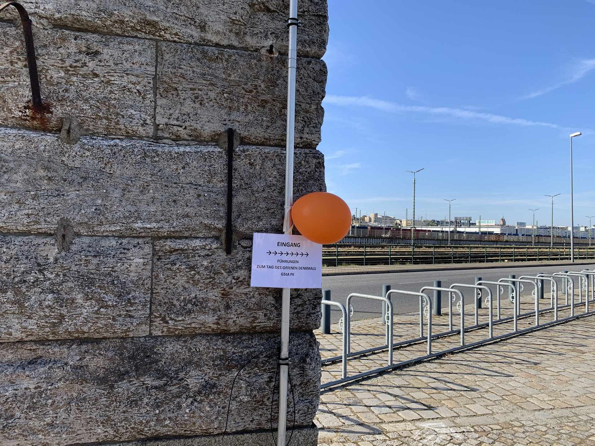 ein Luftballon hängt an einem Schild an einer Wand