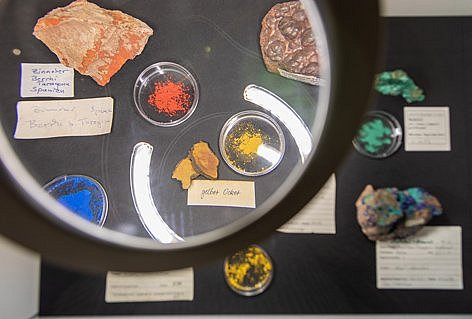 Verschiedene Mineralien in Schälchen auf schwarzem Untergrund