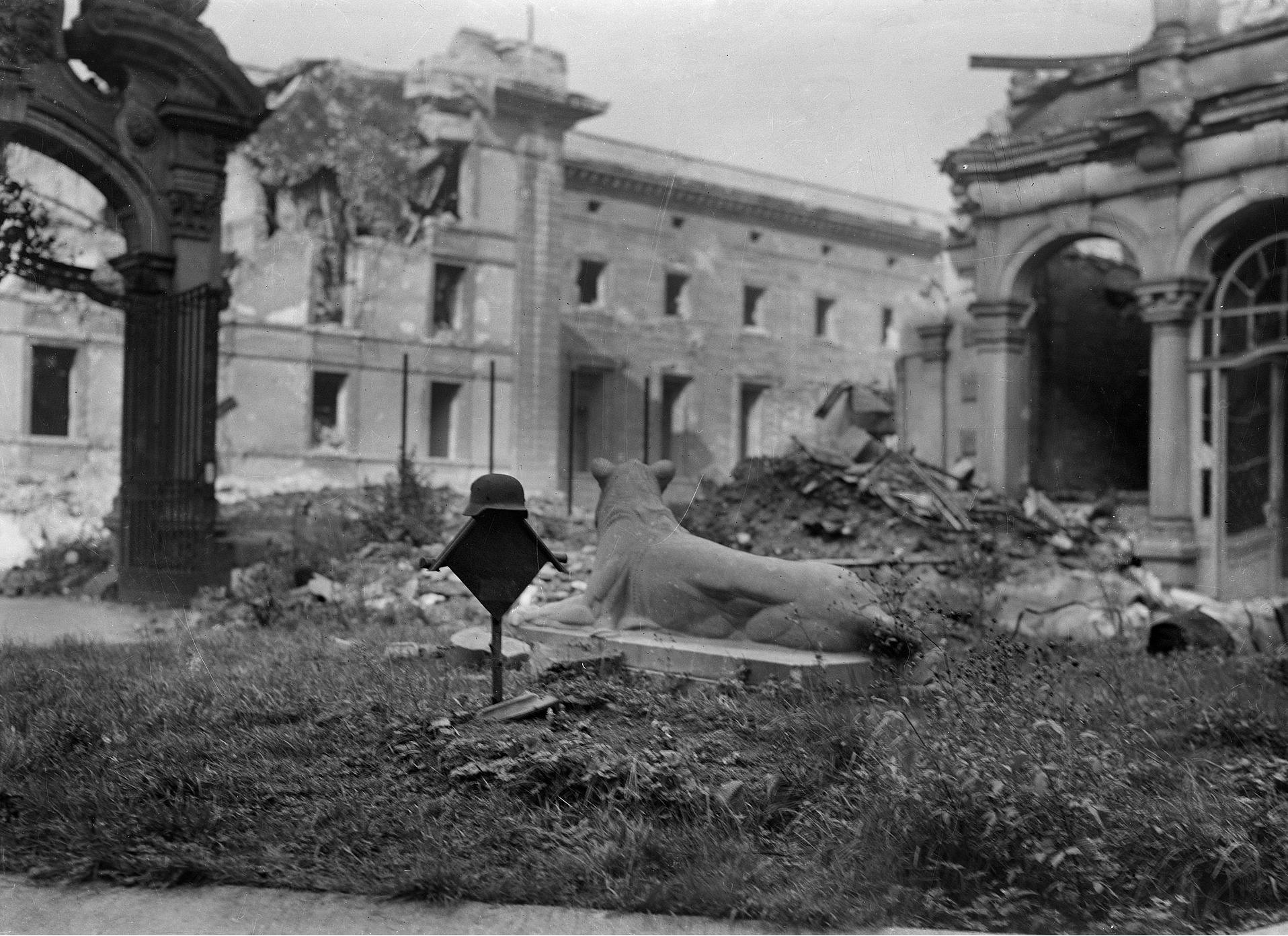 Historisches Foto einer Löwenstatue inmitten von teilweise zerstörten Häusern