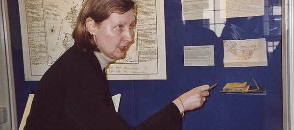 Ausstellung „Brandenburg, Preußen und Europa Frau zeigt auf Objekte in einer Wandvitrine