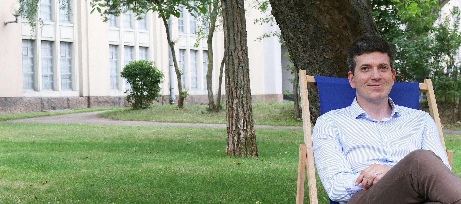 Ein Mann sitzt auf einem Stuhl in einem Garten