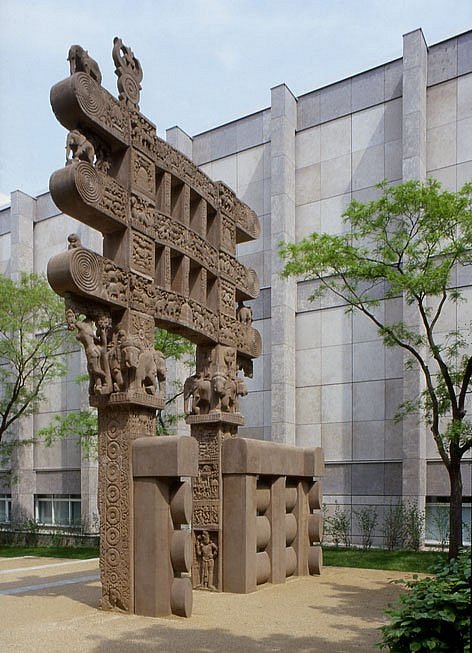 Indisches Sandsteintor mit Ornamenten vor einem Gebäude