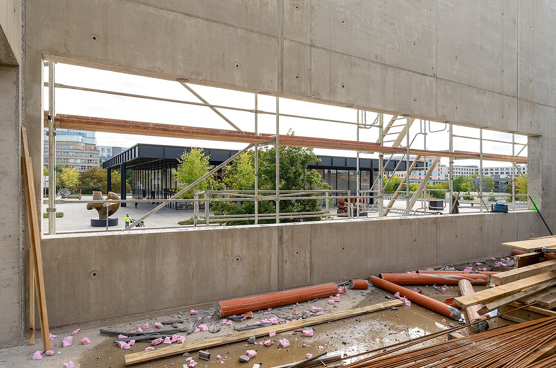 Blick aus einem noch unbeglasten Fensters eines im Bau befindlichen Hauses auf die Neue Nationalgalerie