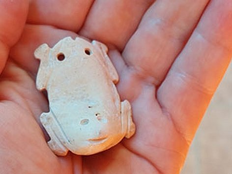 Eine Hand hält ein Keramikobjekt