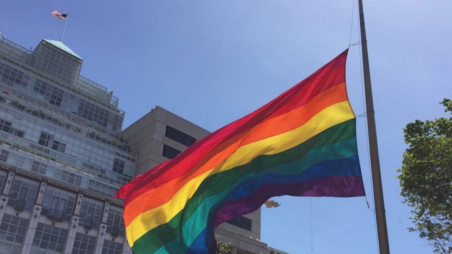 Foto einer Regenbogenflagge vor einem Gebäude