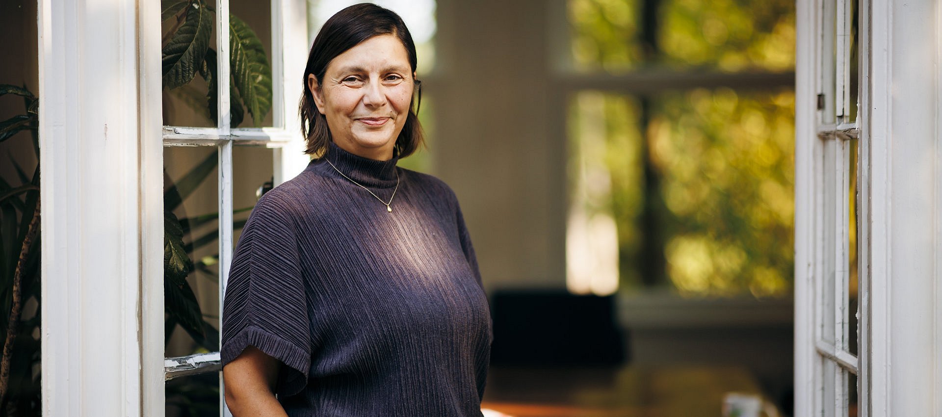 Portrait einer Frau vor einer weißen Tür