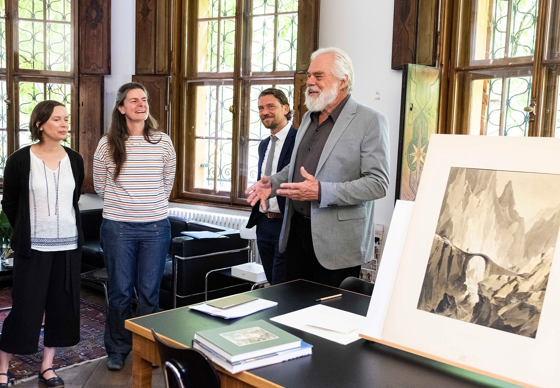 Vier Menschen stehen neben einem Kunstwerk