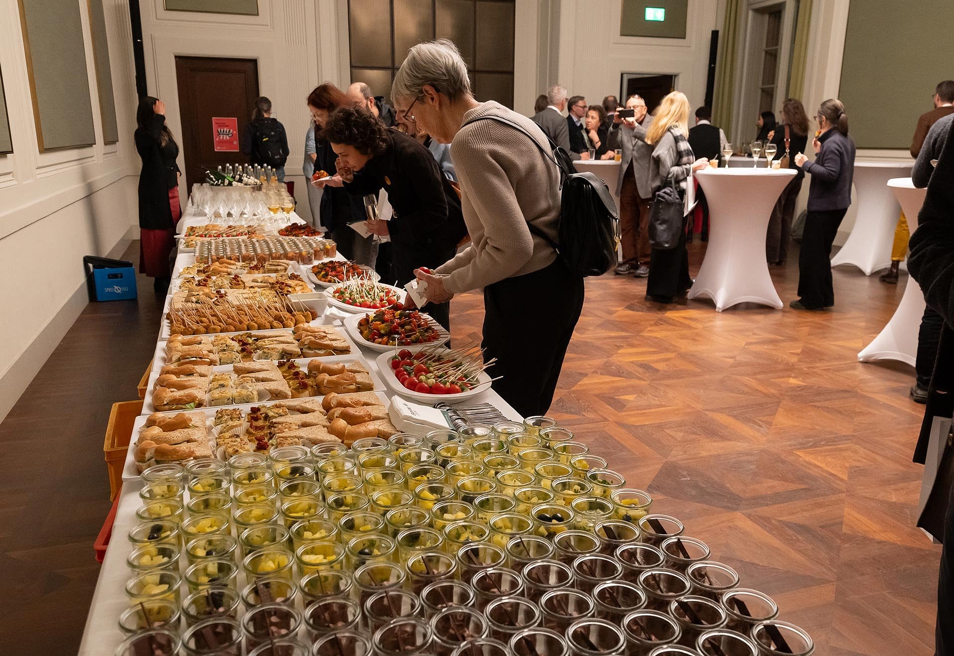 Buffet, davor Menschen, die sich Essen nehmen