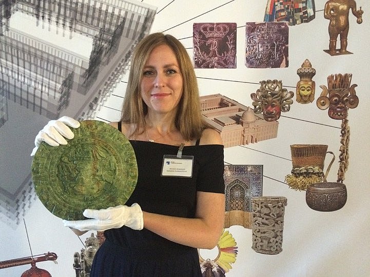 Eine Frau hält einen grünen Teller in der Hand (öffnet Vergrößerung des Bildes)