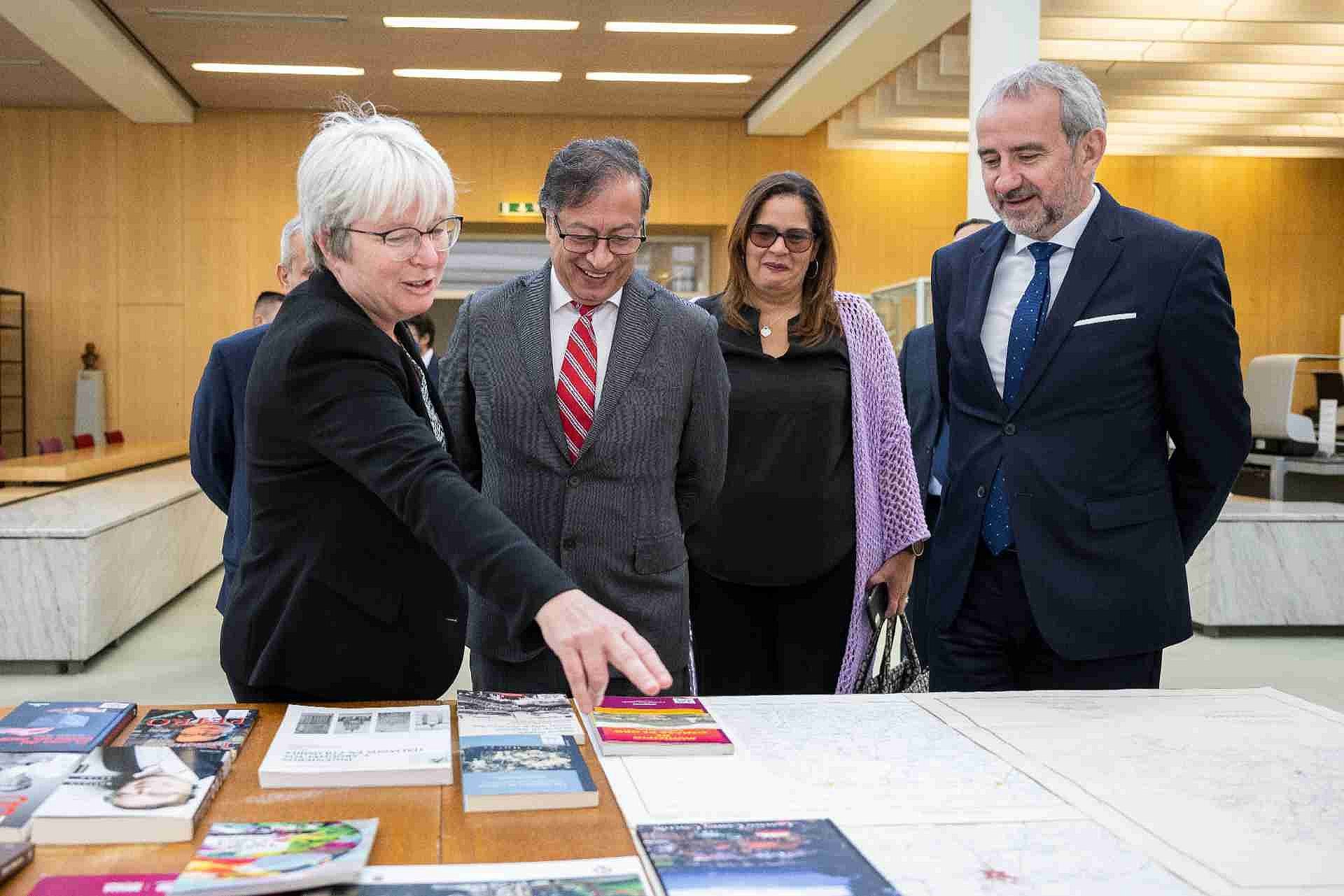 Vier Personen vor einem Tisch mit Büchern
