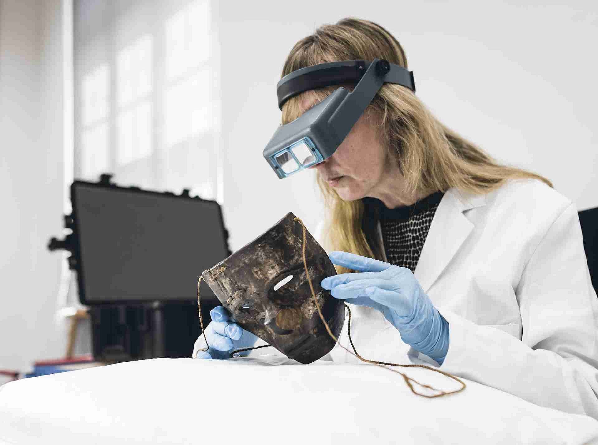 Frau untersucht Maske