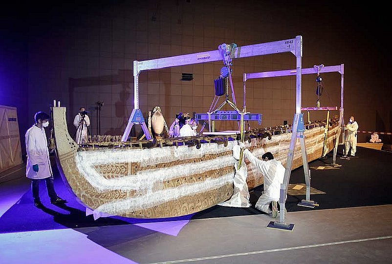 Ein Boot wird in einem musealen Innenraum von mehreren Personen verpackt und zum Transport vorbereitet (öffnet Vergrößerung des Bildes)
