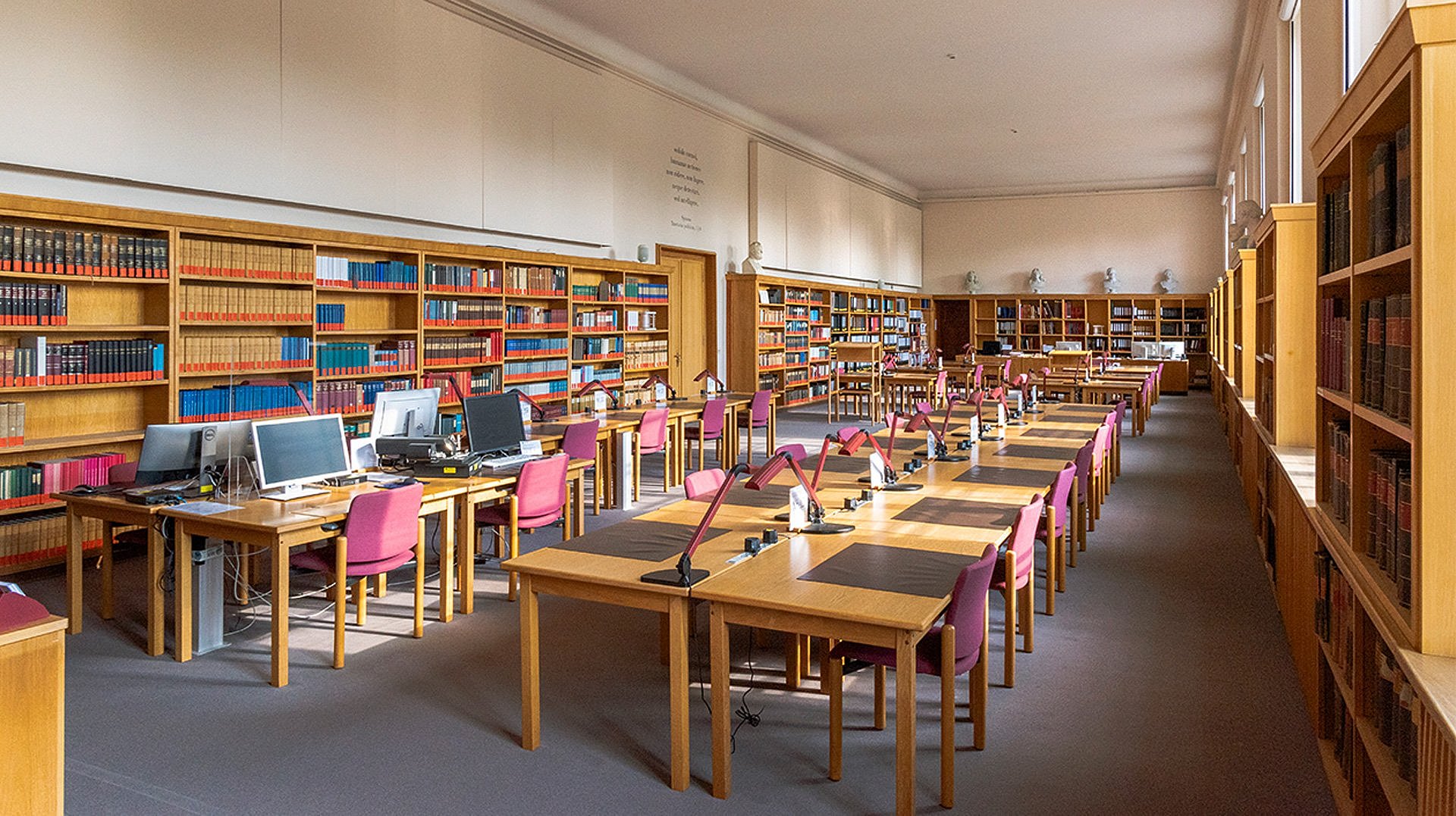 Großer Raum mit Bücherregalen und Tischen mit Stühlen