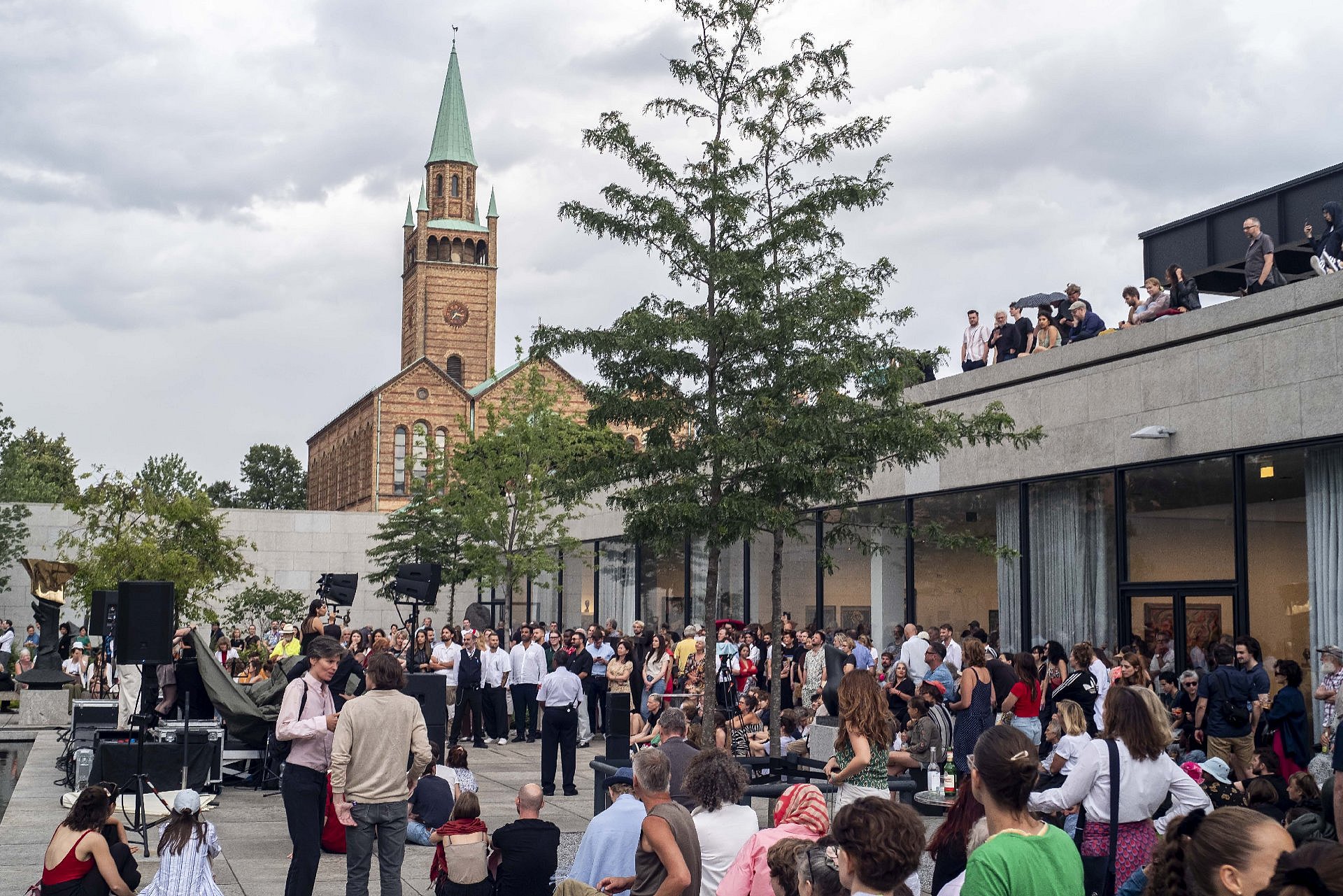 Ein Innenhof voller Menschen, im Hintergrund eine Kirche