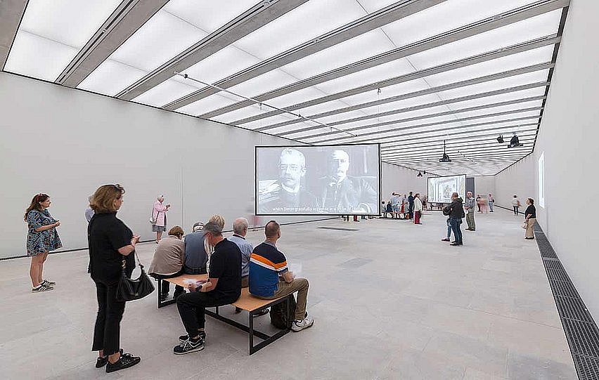 Die Sonderausstellungshalle ist ein länglicher fensterloser Raum mit weißen Wänden und ausgiebiger indirekter Beleuchtung (öffnet Vergrößerung des Bildes)
