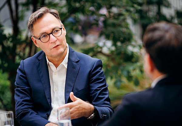 Kam 2021 von der SLUB Dresden nach Berlin: Achim Bonte Ein Mann sitzt an einem Tisch und erzählt