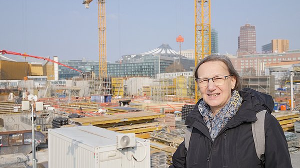 Frau blickt auf Baustelle
