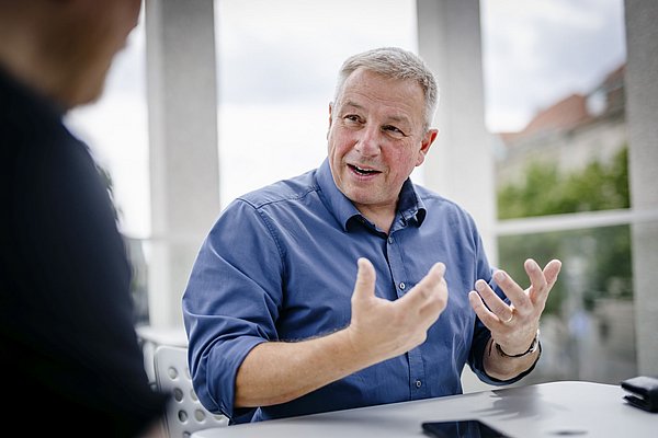 Matthias Wemhoff sitzt und gestikuliert während eines Interviews