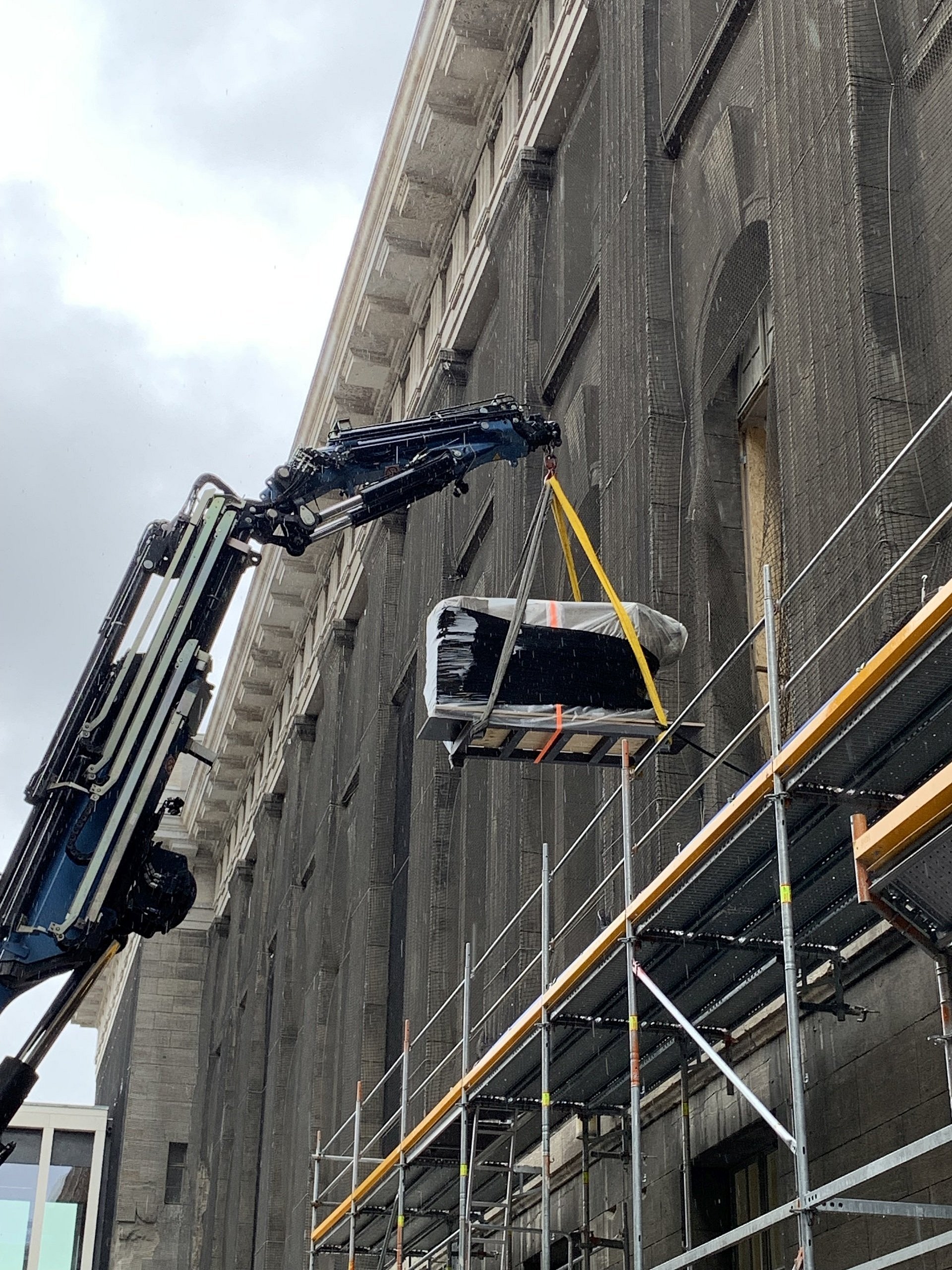 Kran hebt Objekt aus Fenster
