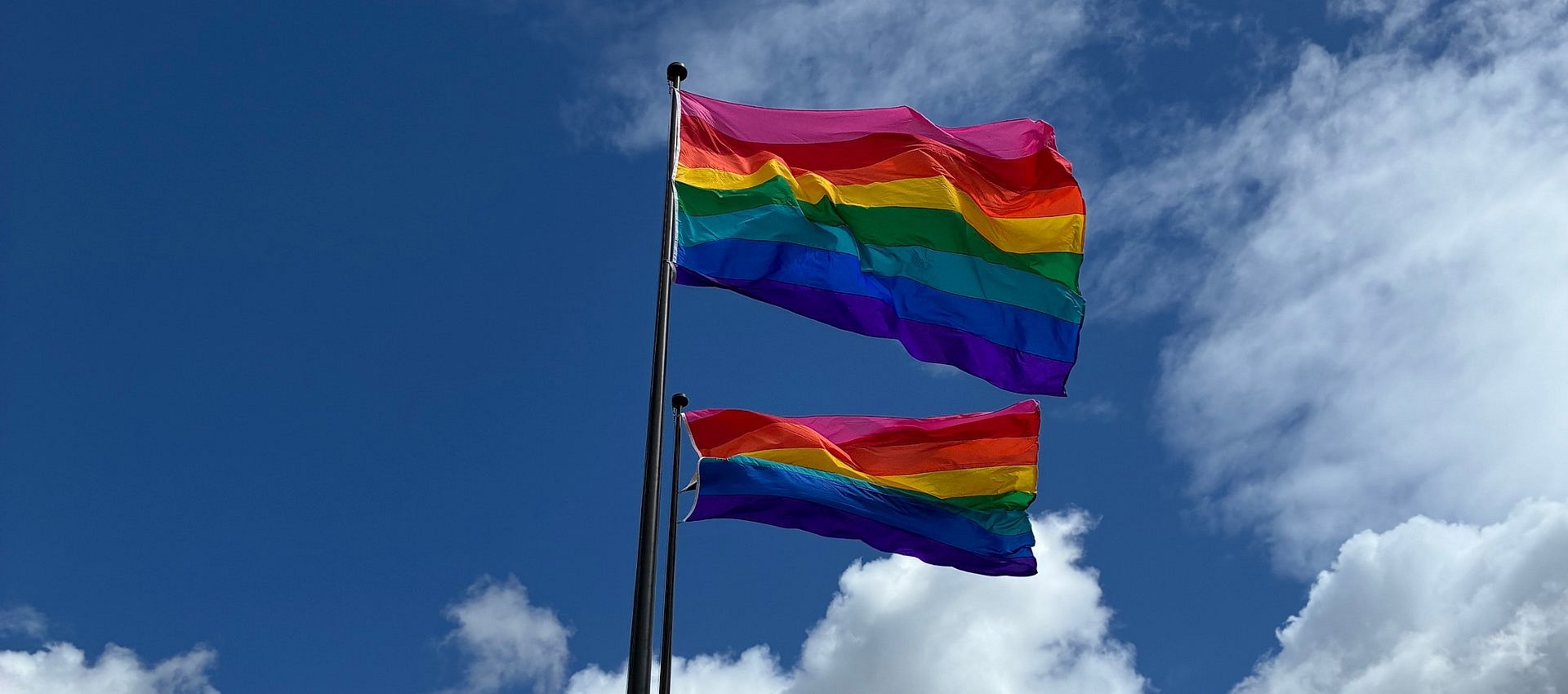 eine Regenbogenflagge vor dem Himmel