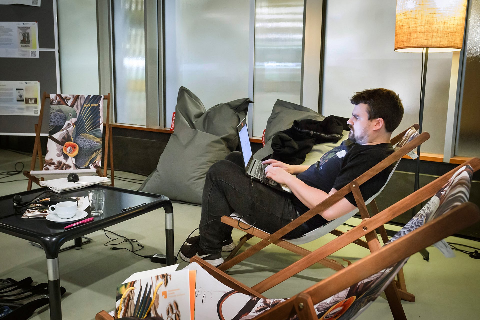 Mann arbeitet in Liegestuhl am Laptop