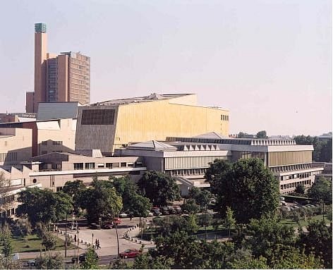 Moderne Gebäude an einem Platz hinter Bäumen