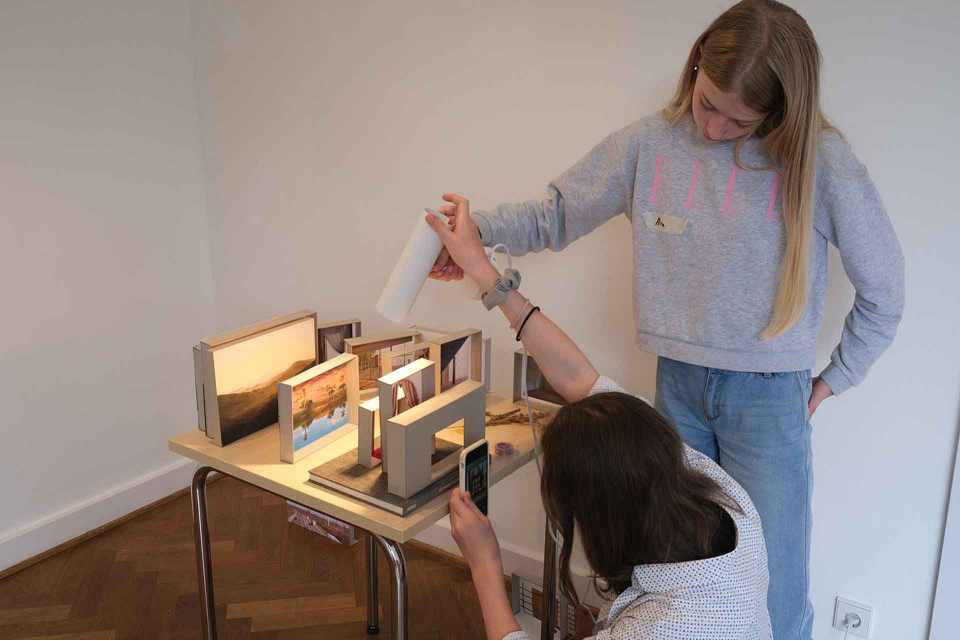 Zwei Mädchen beleuchten Architekturmodelle