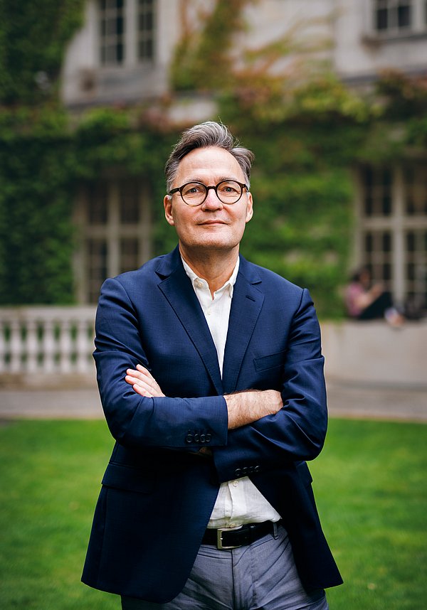 Seit 2021 Generaldirektor der Staatsbibliothek zu Berlin: Achim Bonte Mann im blauen Sakko steht in einem begrünten Innenhof