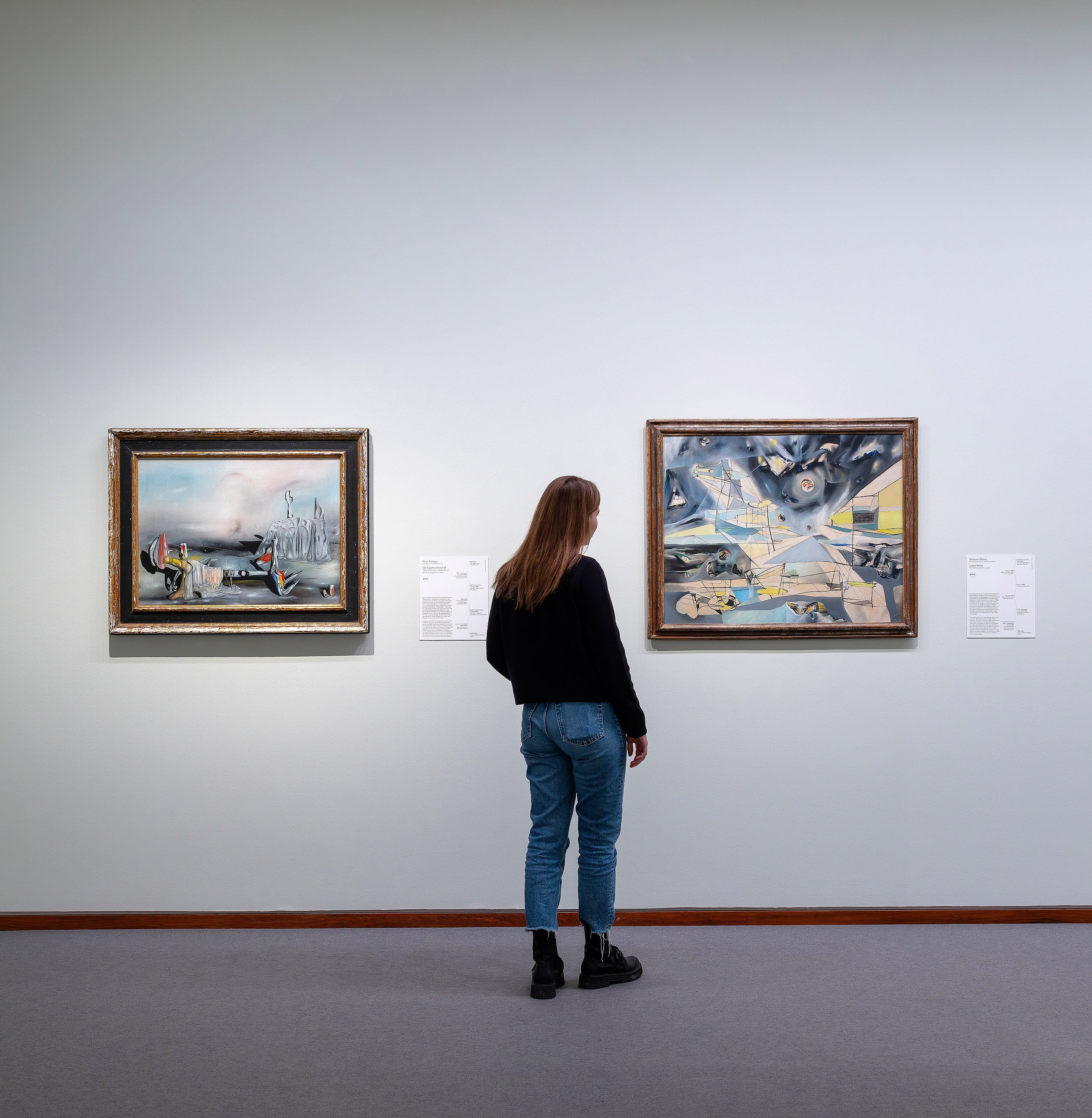 Frau betrachtet Bilder in einer Ausstellung