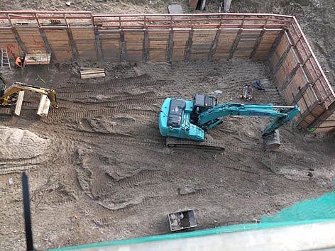 Blick auf einen Bagger in einer Baugrube.