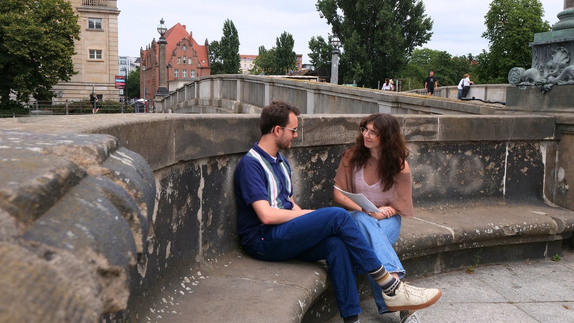 Zwei Menschen im Gespräch auf einer Steinbank