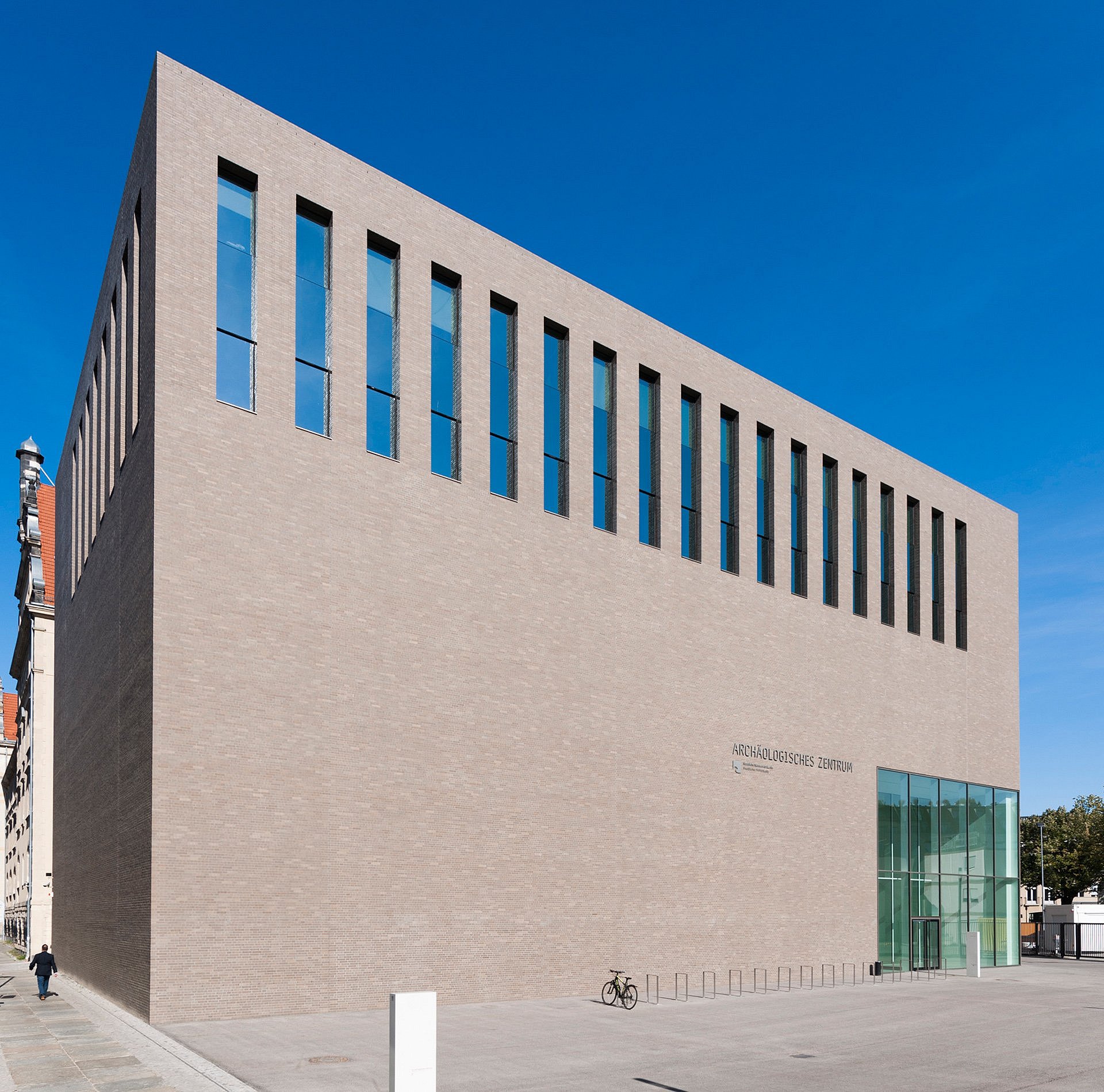 Quaderförmiges Gebäude aus Backstein mit eingelassenen Glasfenstern