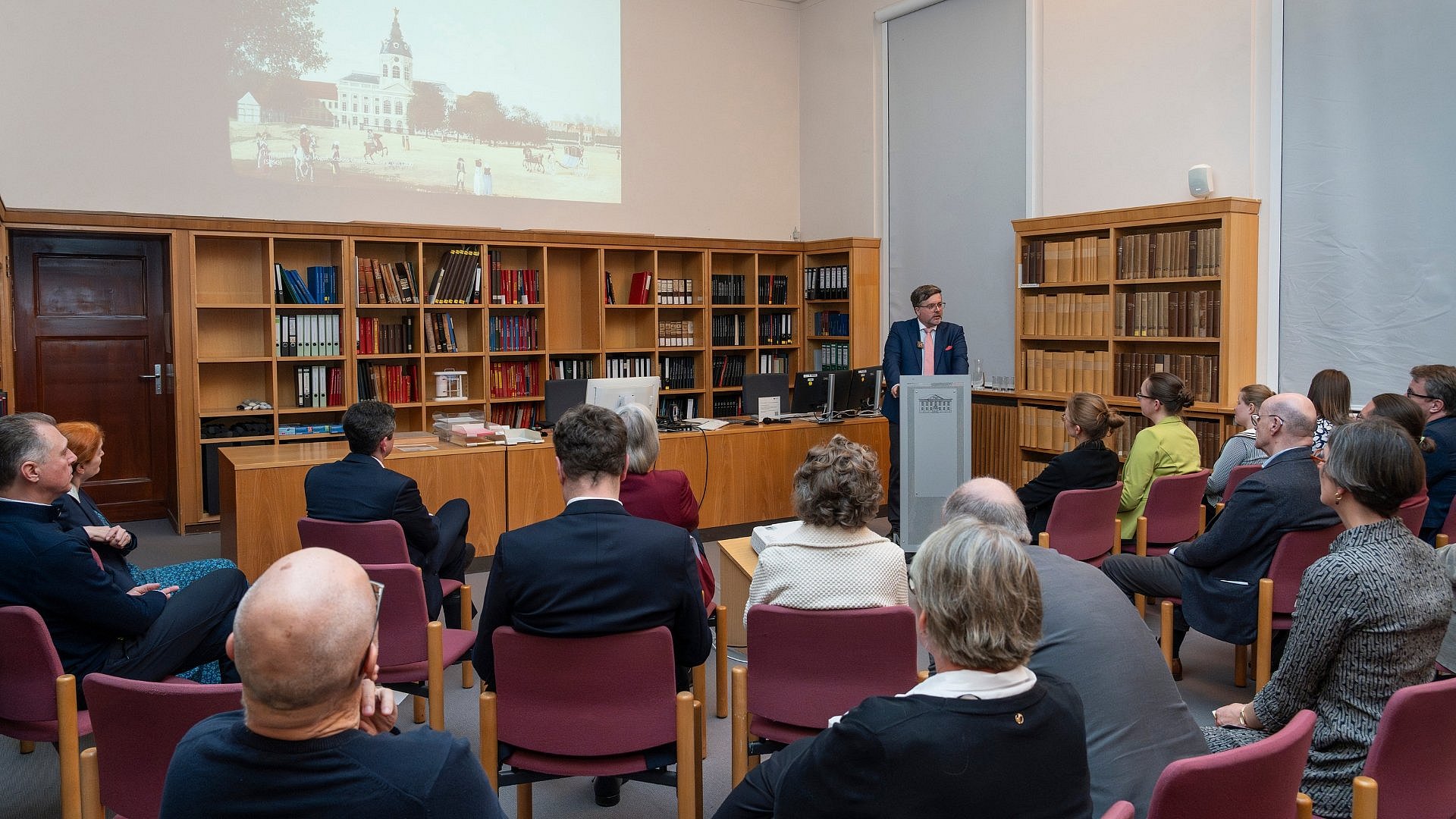 a reading room full of people sitting and listening to a talk
