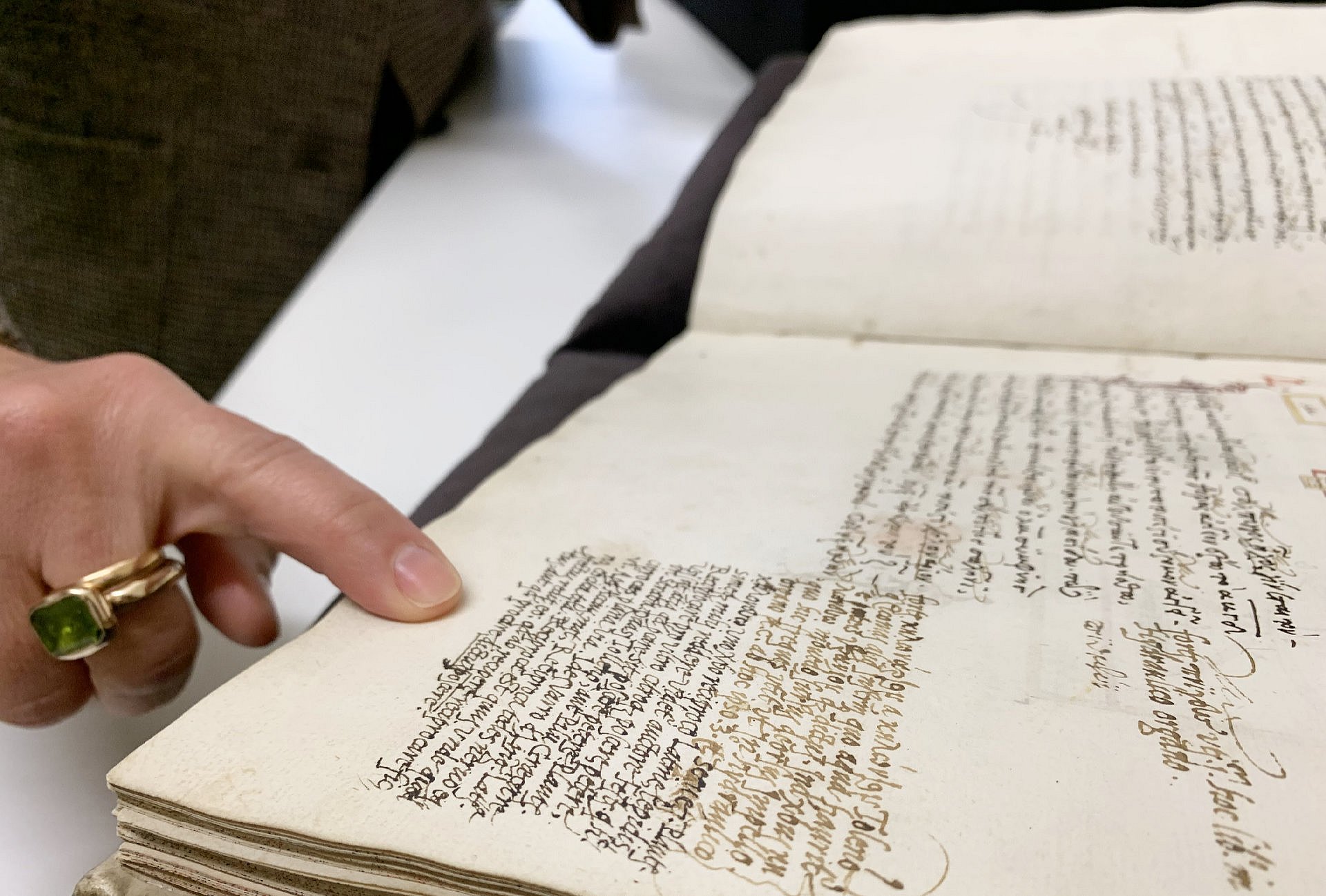 Finger mit Ring zeigt auf alte Buchseite
