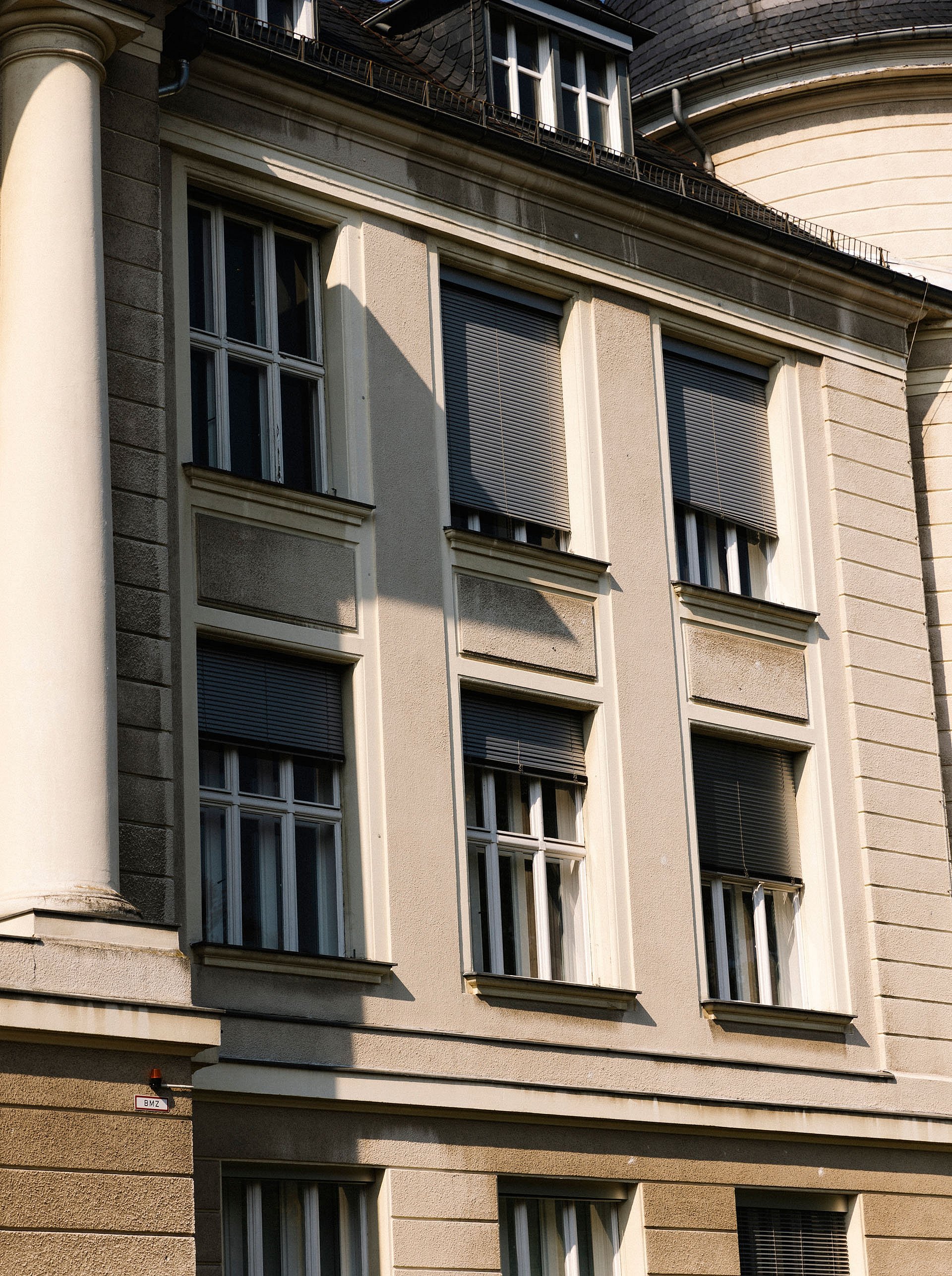 Teilweise mit Rolläden behangene Fenster eines Institutsgebäudes