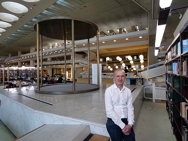 C. Mathieu Mann posiert im Lesesaal für ein Foto