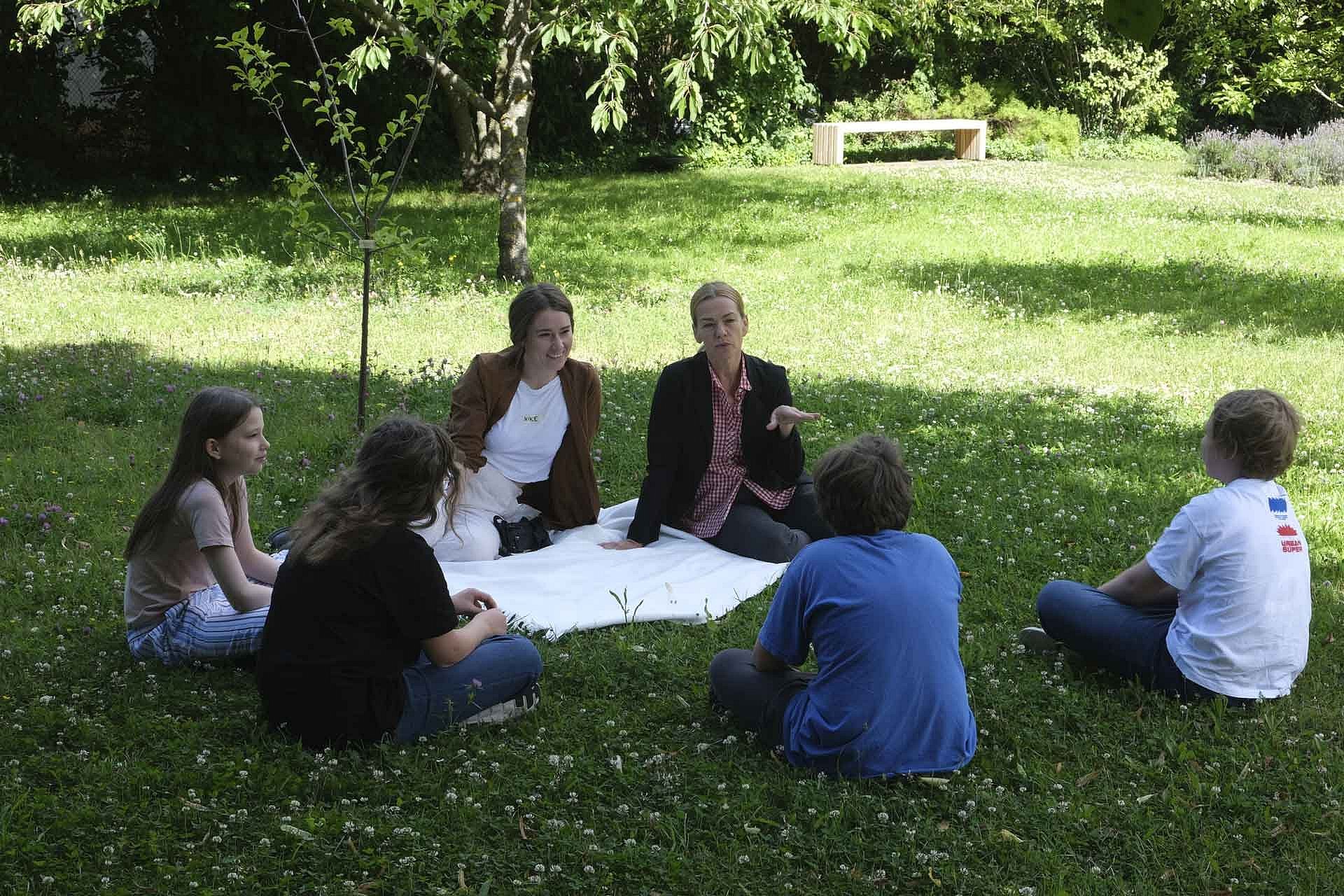 Workshopgruppe sitzt in der Wiese