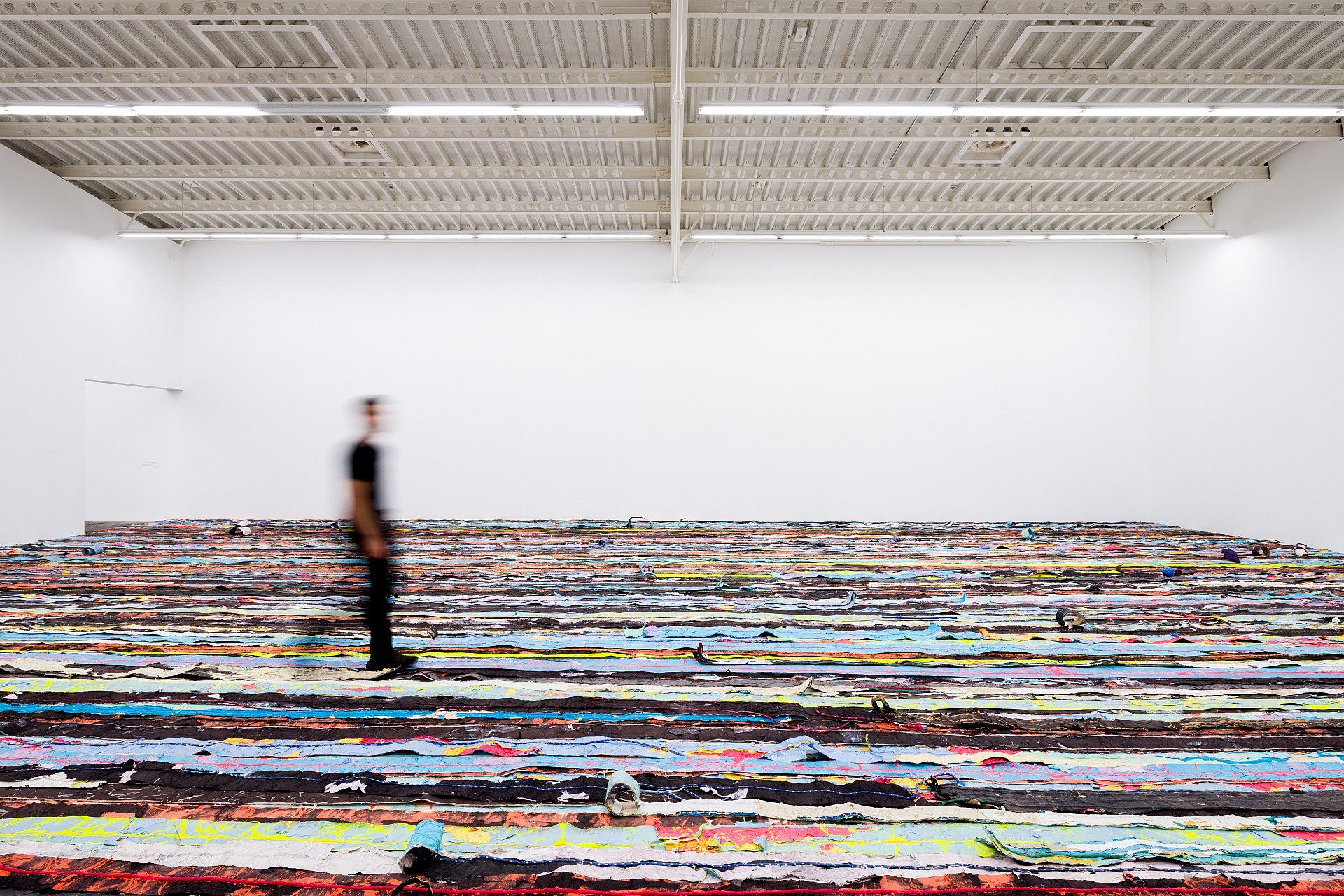 Mann läuft über das interaktive Kunstwerk Float des Künstlers Mark Bradford