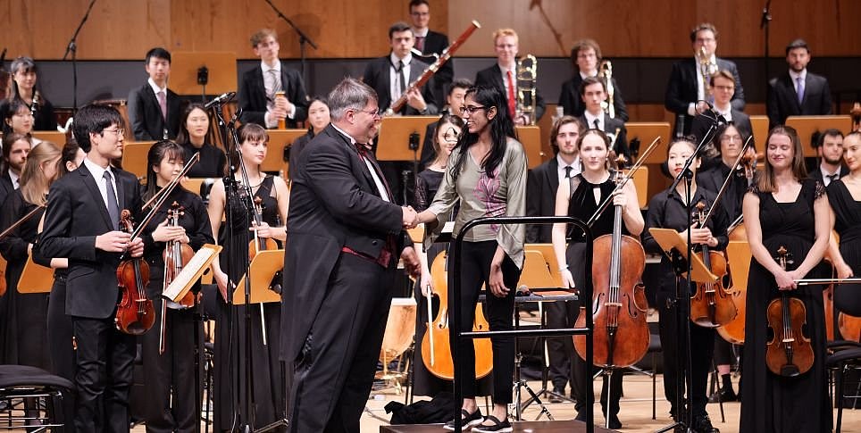 Die Komponistin Zara Ali auf der Bühne vor einem Orchester