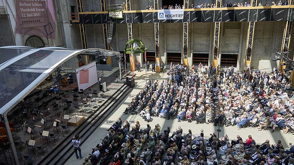 Blick von oben in eine Halle, in der ein Publikum vor einer Bühne sitzt (öffnet Vergrößerung des Bildes)